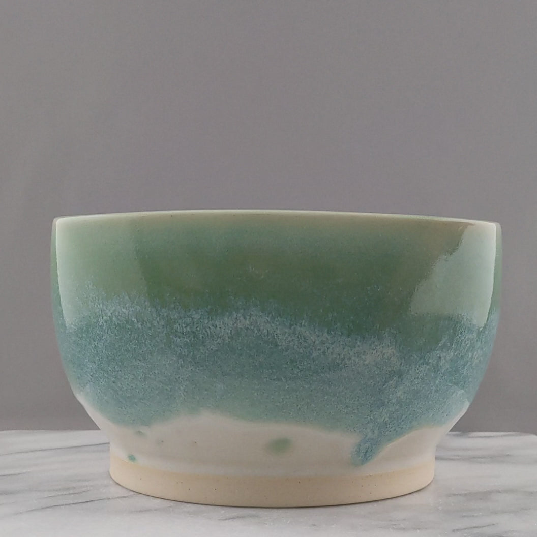 Video is shot from the side to show all sides of the green and white bowl and then the bowl is lifted to see the inside