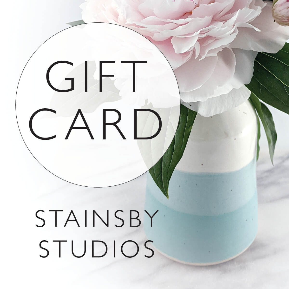 White and turquoise vase holding a pink peony with the words Gift Card in a circle and Stainsby Studios written below