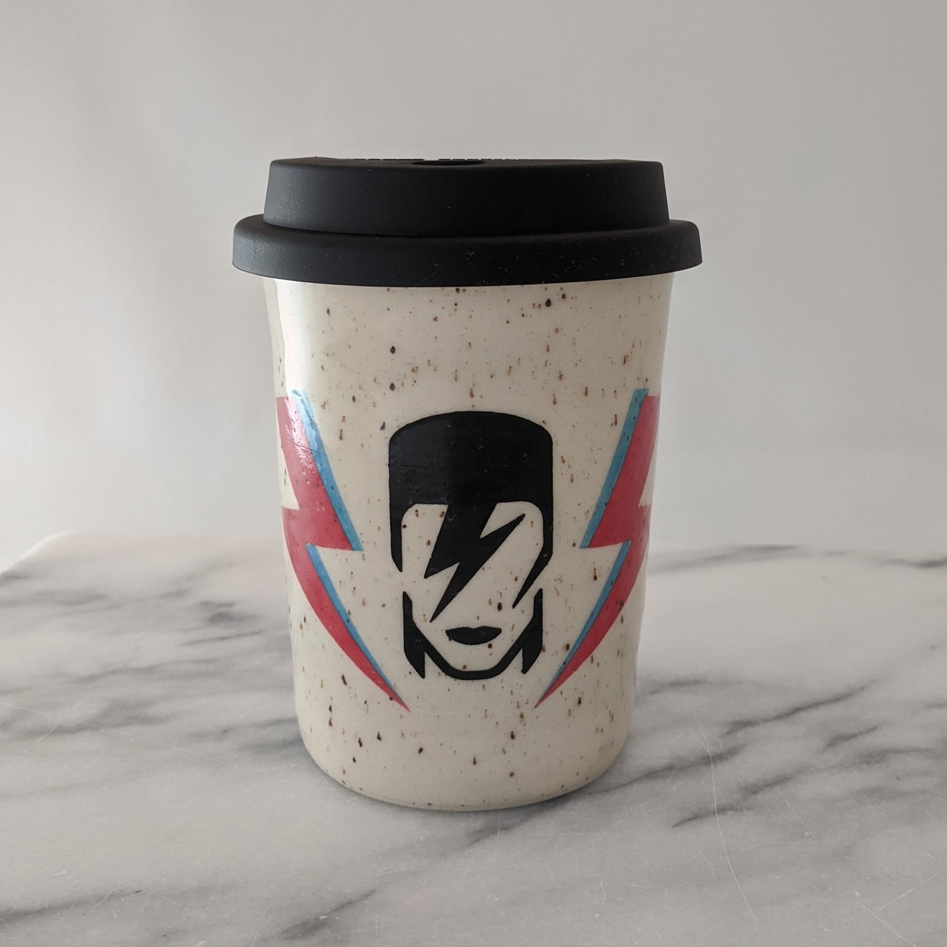 Bowie travel mug in speckled clay with a black silicone lid