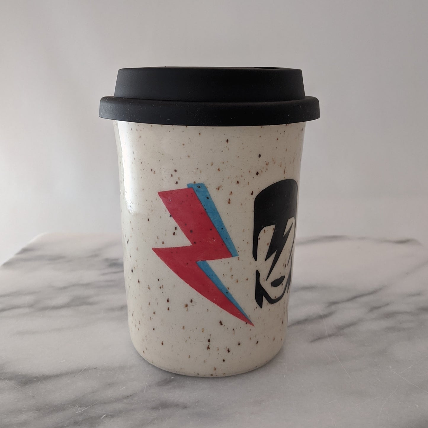 Bowie travel mug in speckled clay with a black silicone lid