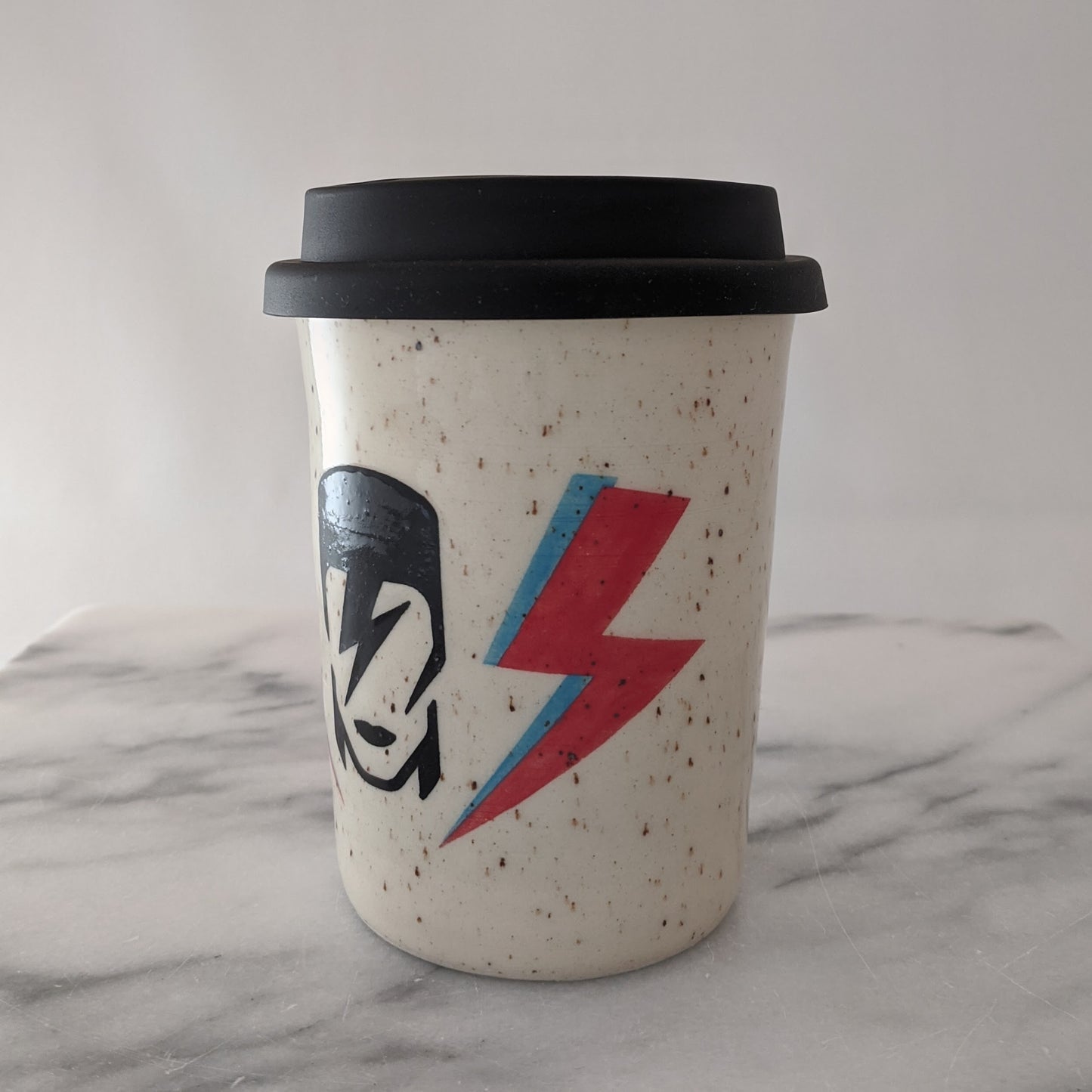 Bowie travel mug in speckled clay with a black silicone lid