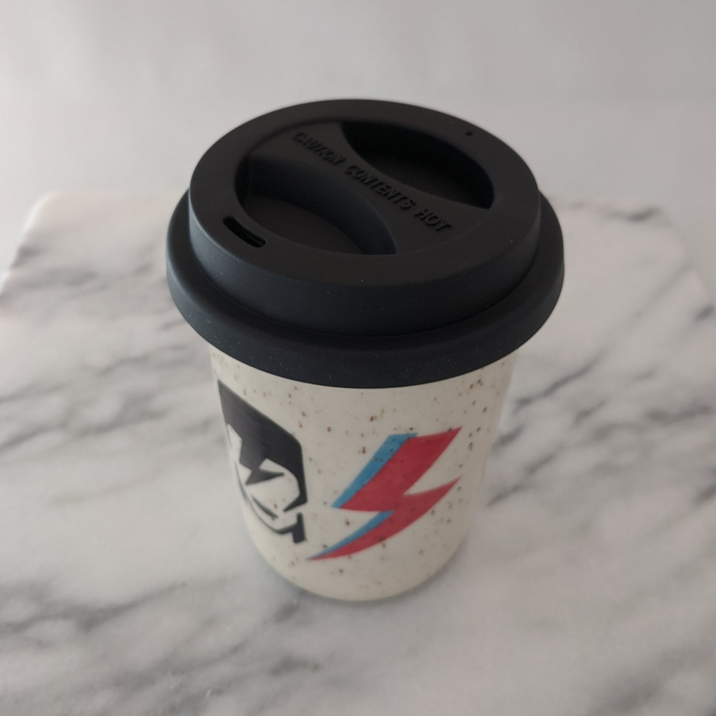 Bowie travel mug in speckled clay with a black silicone lid